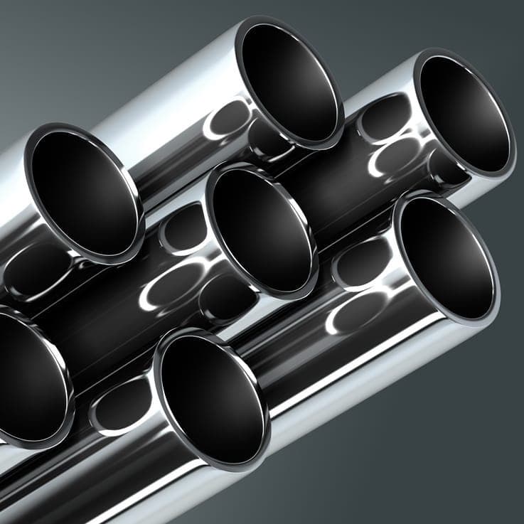 Conjunto de tubería de acero inoxidable de diferentes diámetros sobre una superficie oscura.