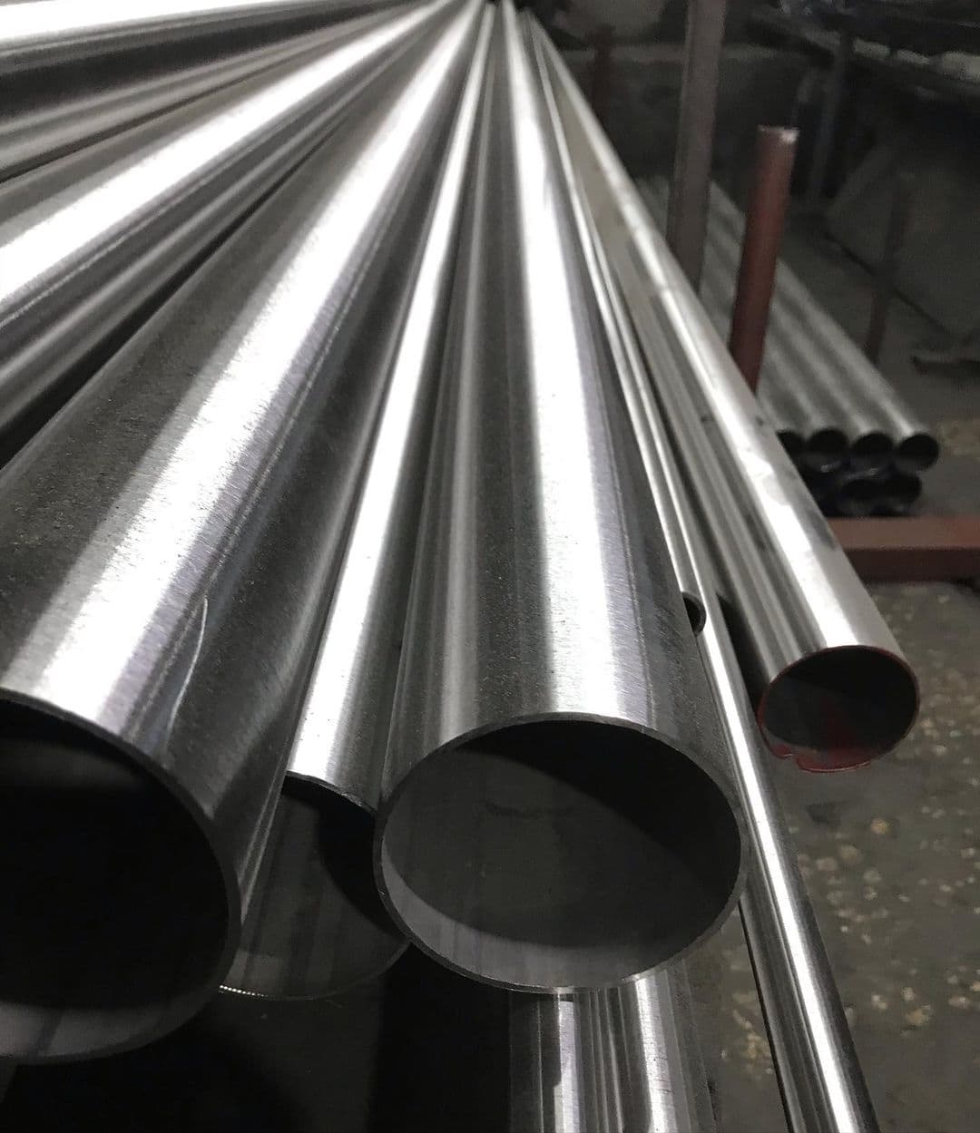 tubería de acero inoxidable en un entorno industrial, con un enfoque en los extremos de los tubos brillantes y pulidos.